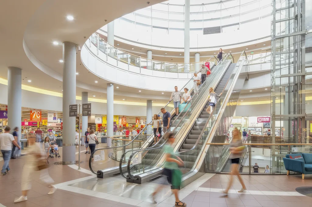 Serving Local Communities Shoppers using escalators within Galeria Pestka shopping centre