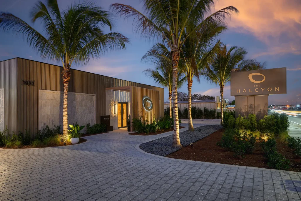 The Halcyon Sales Gallery Exterior at Dusk The Halcyon sales gallery and brand signage illuminated at dusk in Naples, Florida